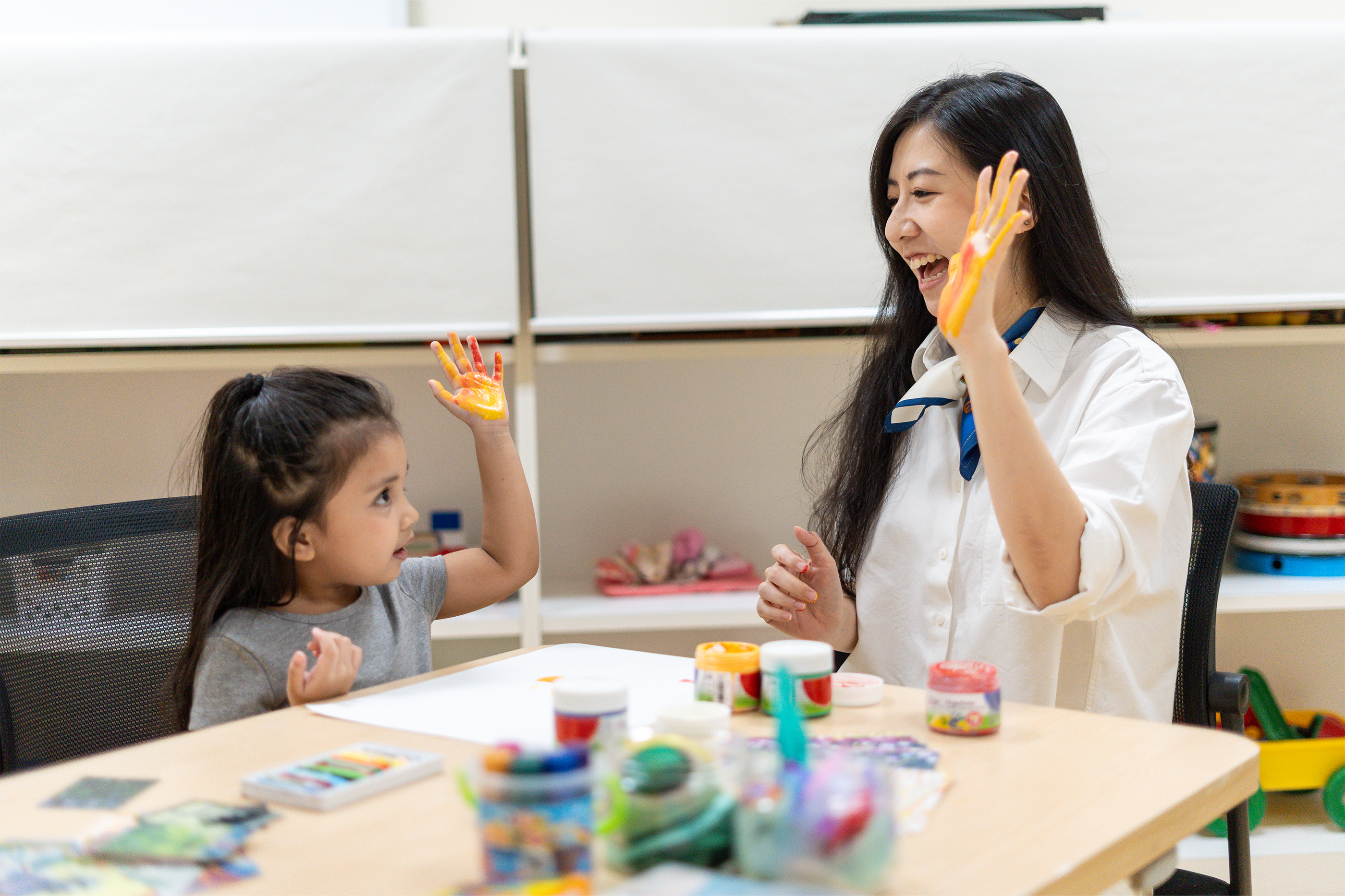 Child and caregiver doing finger painting together